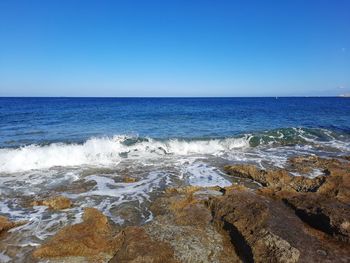 Scenic view of sea against clear blue sky