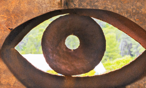 Close-up of rusty metal hanging from hole