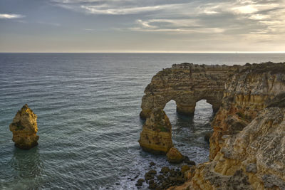 Rock formation in sea against sky