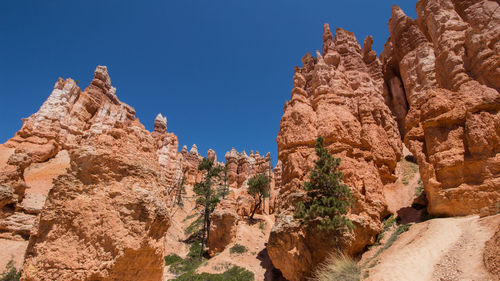 Low angle view of rocks against blue sky