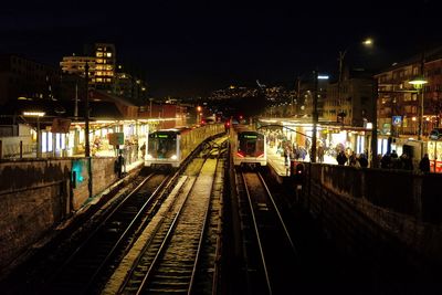 Railroad tracks against sky at night