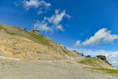 Road by mountain against blue sky