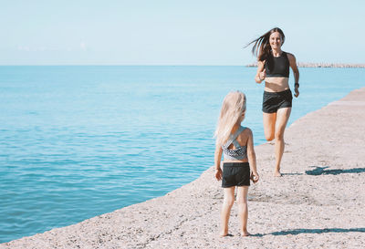 Woman with daughter by sea