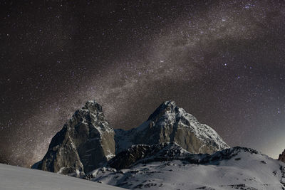 Scenic view of snowcapped mountains against sky at night