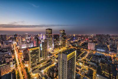 High angle view of illuminated cityscape against sky at night