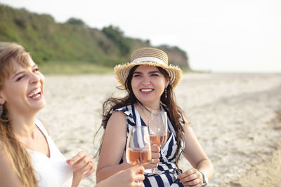 Portrait of a beautiful young woman drinking water on beach