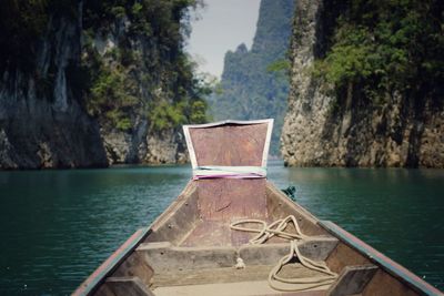 Longtail boat over river against rock formations