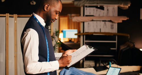 Midsection of man reading book