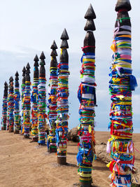 Stack of multi colored lights on beach against sky