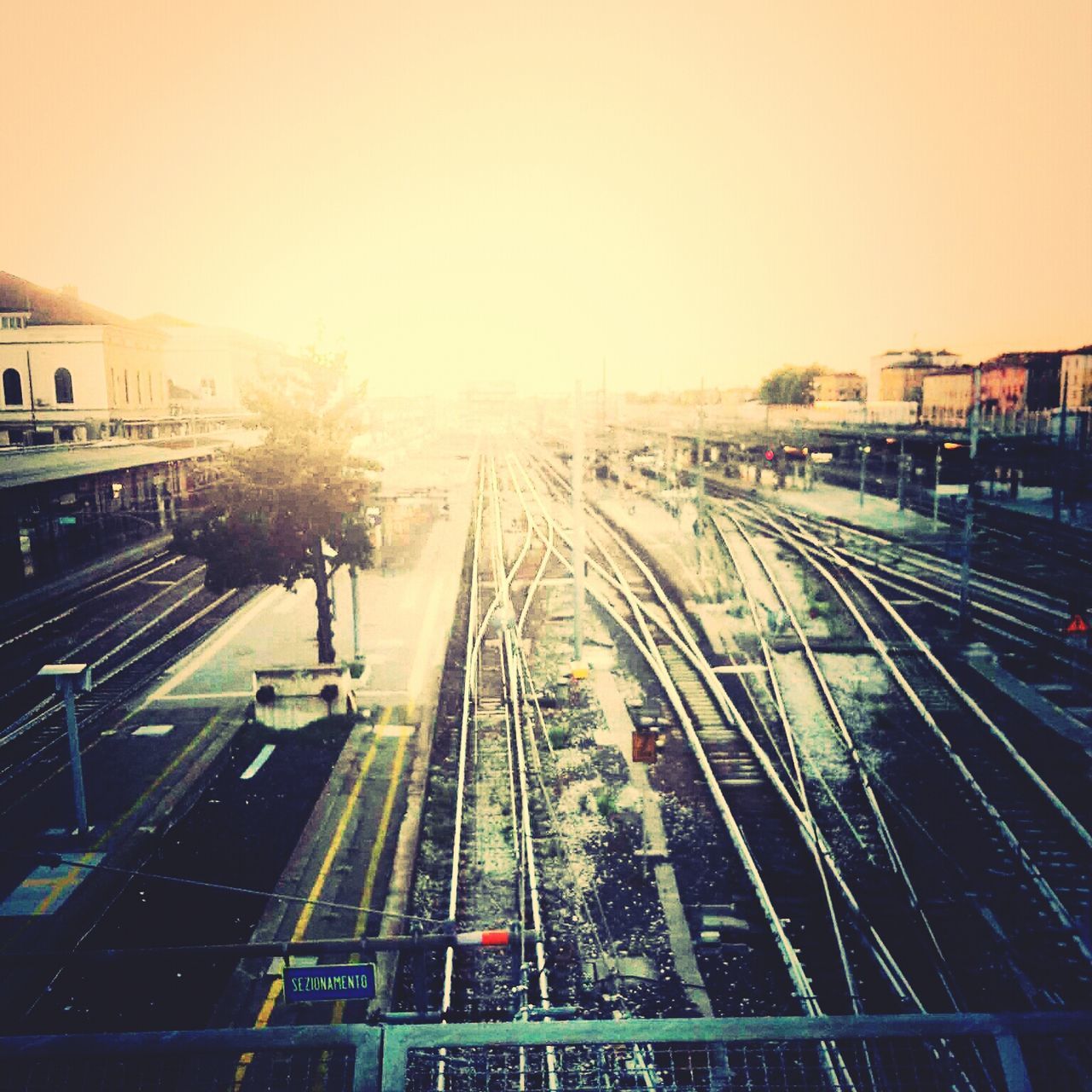 transportation, railroad track, rail transportation, high angle view, public transportation, mode of transport, clear sky, railway track, on the move, motion, diminishing perspective, vanishing point, travel, railroad station, the way forward, train - vehicle, sky, railroad station platform, land vehicle, city