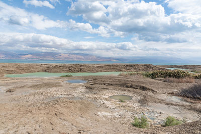 Sinkhole filled with turquoise water, near dead sea coastline. hole formed when underground salt is