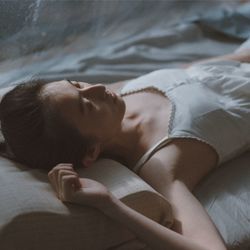 Close-up of woman sleeping on bed at home