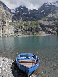 Boat moored on lake against mountains