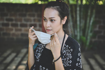 Young women remove a surgical protection from her face