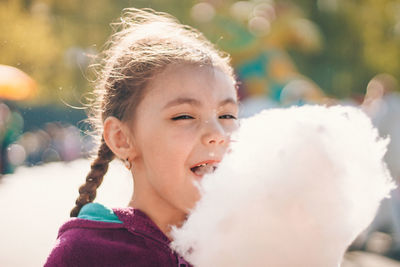 Close-up of cute girl eating cotton candy