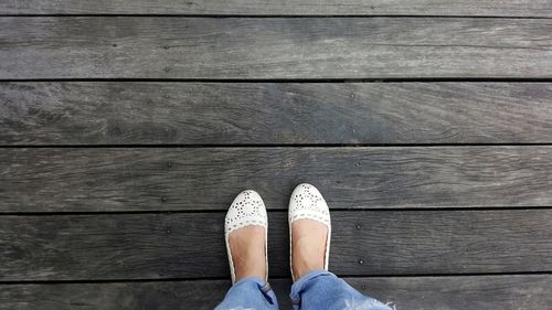 Low section of woman standing on hardwood floor