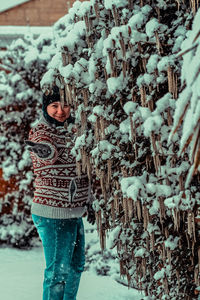 Woman standing on snow covered tree