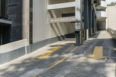 Arrow signs showing exit and entrance with no motorcycle sign on column and height limit