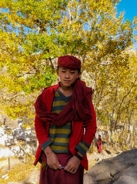 Portrait of young man standing against trees