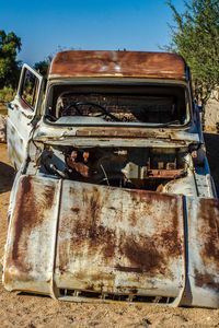 Old rusty car against sky