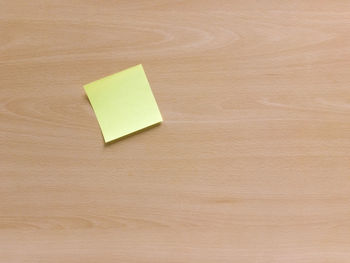 Directly above shot of blank adhesive note on wooden table