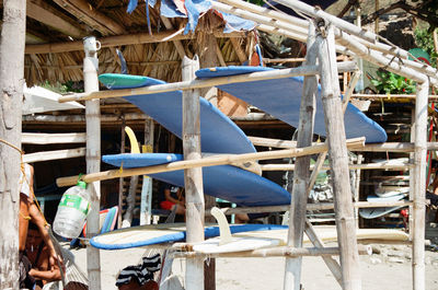 Blue surfboards drying on makeshift bamboo racks