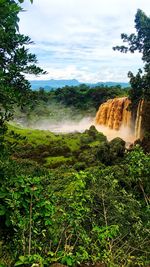 Scenic view of waterfall against sky