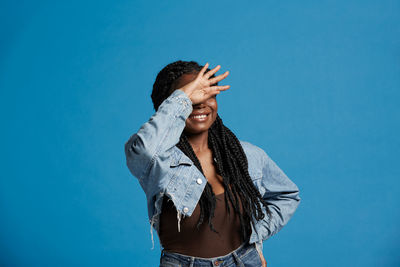 Young woman standing against blue background