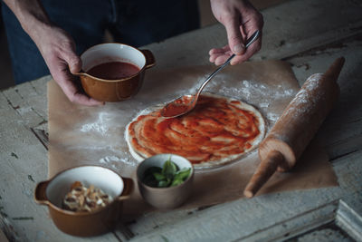 Cropped hand of person preparing food on table