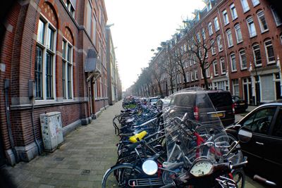 Bicycles parked on street amidst buildings in city