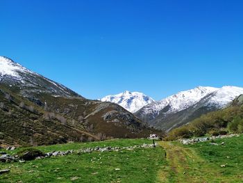 Scenic view of snowcapped mountains against blue sky