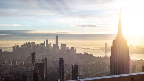 Buildings in city against cloudy sky