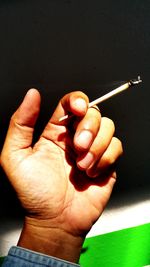 Close-up of hand holding cigarette