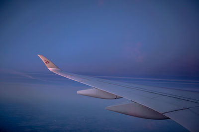 Close-up of airplane wing against blue sky