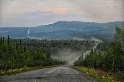 Road amidst trees against sky