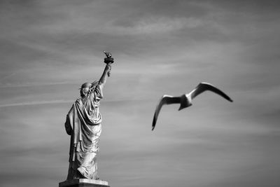 Statue of liberty with seagull against sky