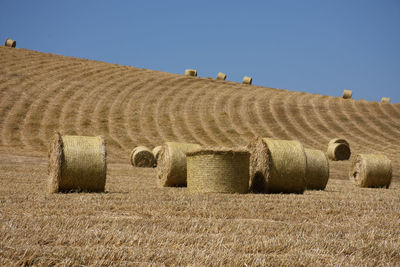 Hay bales on field against sky