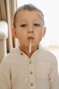 Boy playing with food. child eating cookie, holding it in his mouth