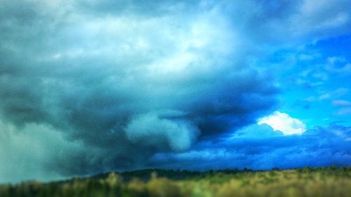 Scenic view of field against cloudy sky