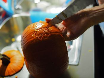 Close-up of hand carving a pumpkin
