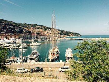 Sailboats moored at harbor against clear sky