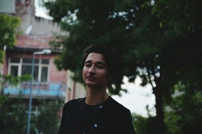 Portrait of smiling man standing against trees