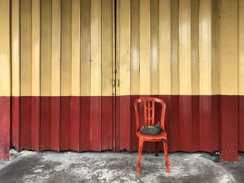 Empty chair against red wall