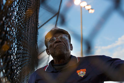 Low angle view of man standing by fence