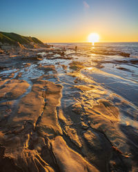 Scenic view of beach against sky during sunset