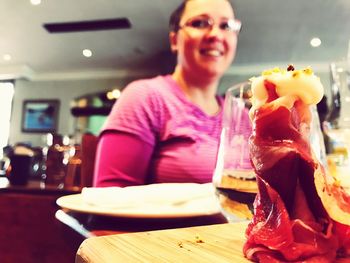 Portrait of smiling man with ice cream in glass on table