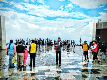 People at observation point against blue sky