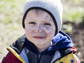 Close-up portrait of boy with soot smear on face