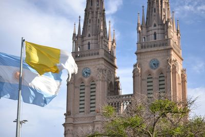 Low angle view of flags by historic building