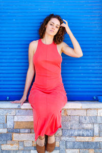 Young woman standing against wall